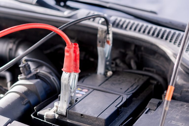 Technician performing on-site car battery replacement and diagnostics in Dubai